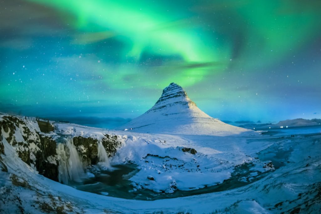 northern light blazing over a peak in Iceland