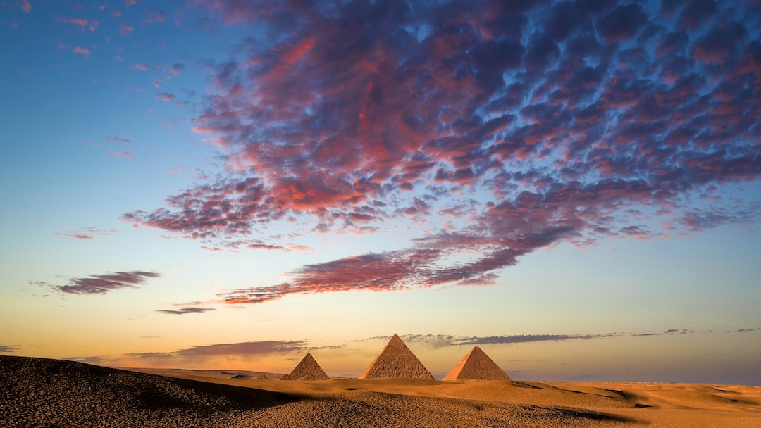 Reddish pink clouds loom over Egypt's ancient pyramids of giza