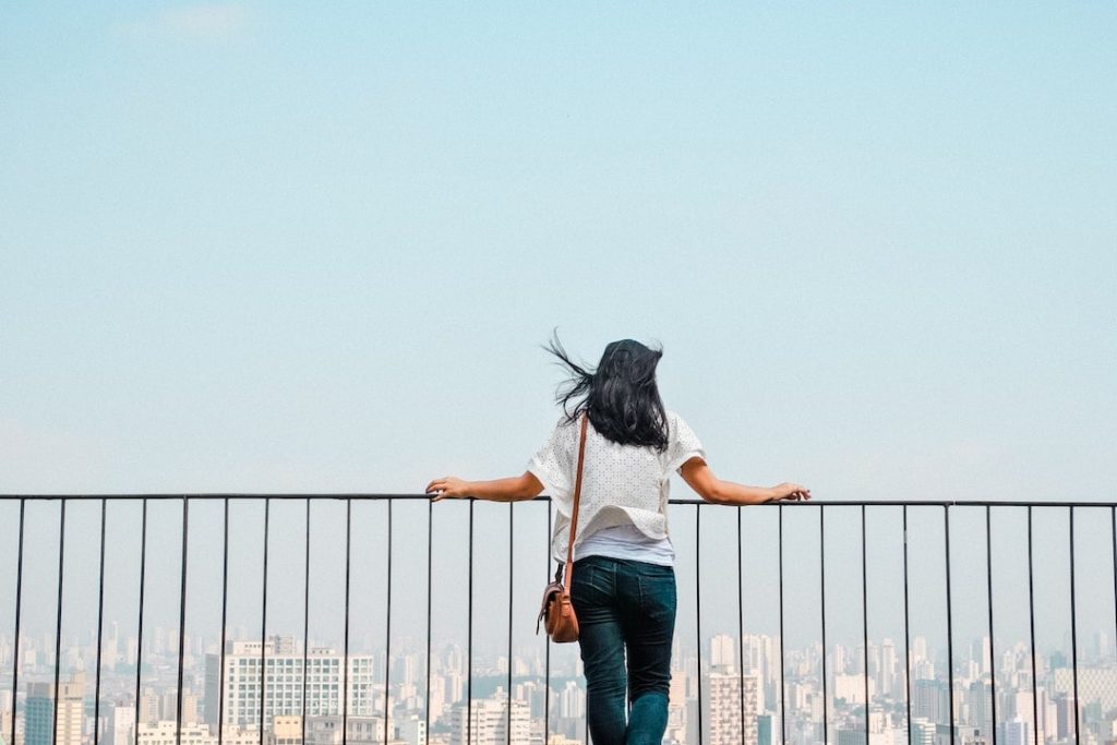 A woman with her back to the camera looks out at the city from the top of Edifício Copan in Sao Paulo, Brazil