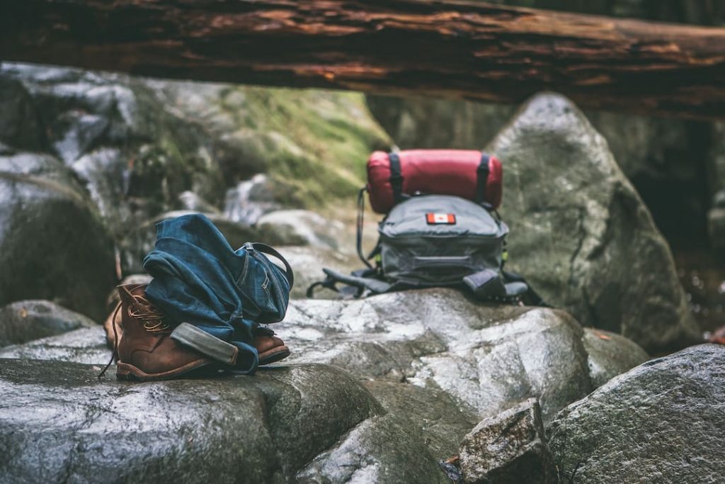 Two backpacks sitting on a rock outdoors