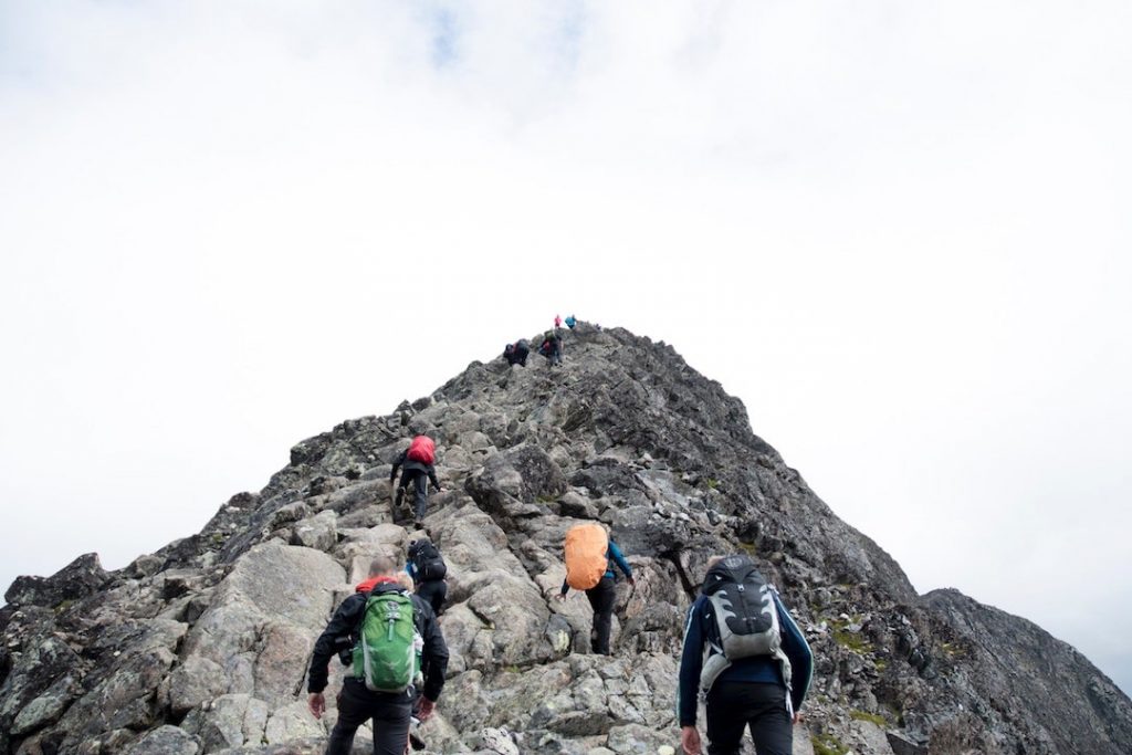 Trekkers i ryggsäckar klättra till toppen av Besseggen, Norge