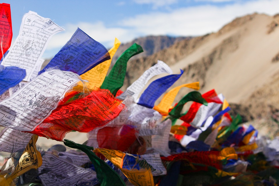 colourful holy flags in blue, white, reg, green and yellow fluttering in the wind