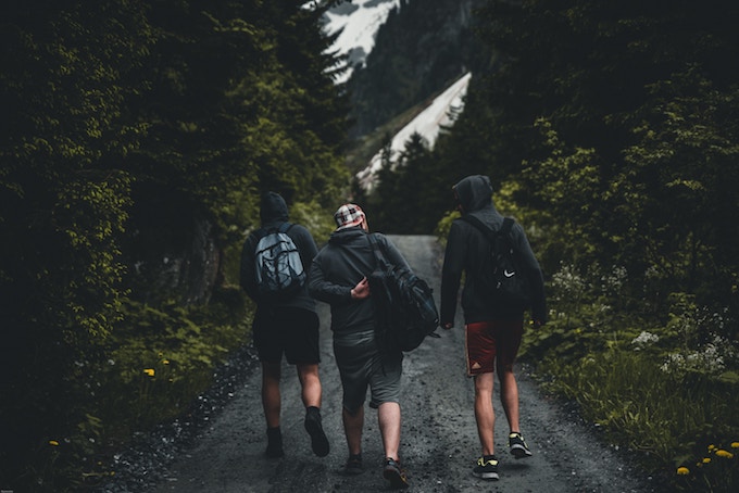 Three friends in shorts and hoodies walking outdoors