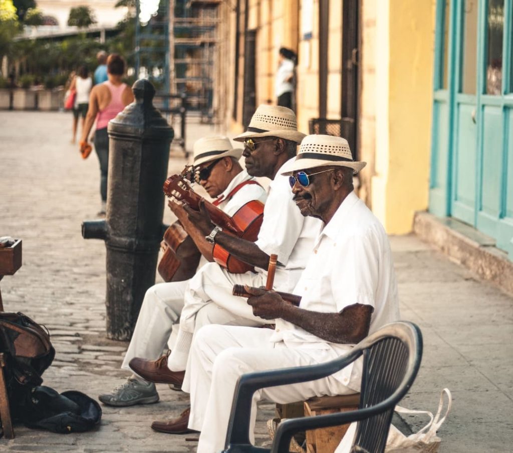 Three men playing instruments on the side of the street in Havana, Cuba
