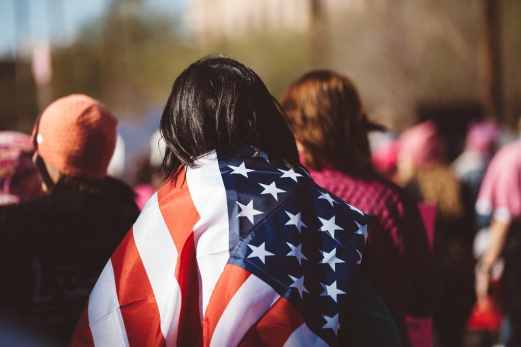 a woman with a USA flag draped over her shoulders