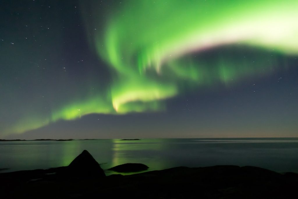 The northern lights over water in Northern Norway