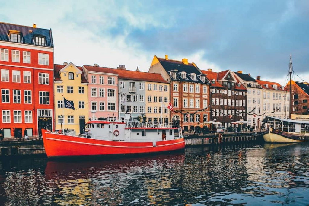 A boat and colourful houses along the harbour in Nyhavn, Copenhagen