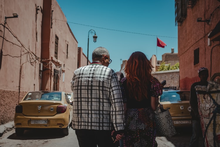 man and woman walk down a road