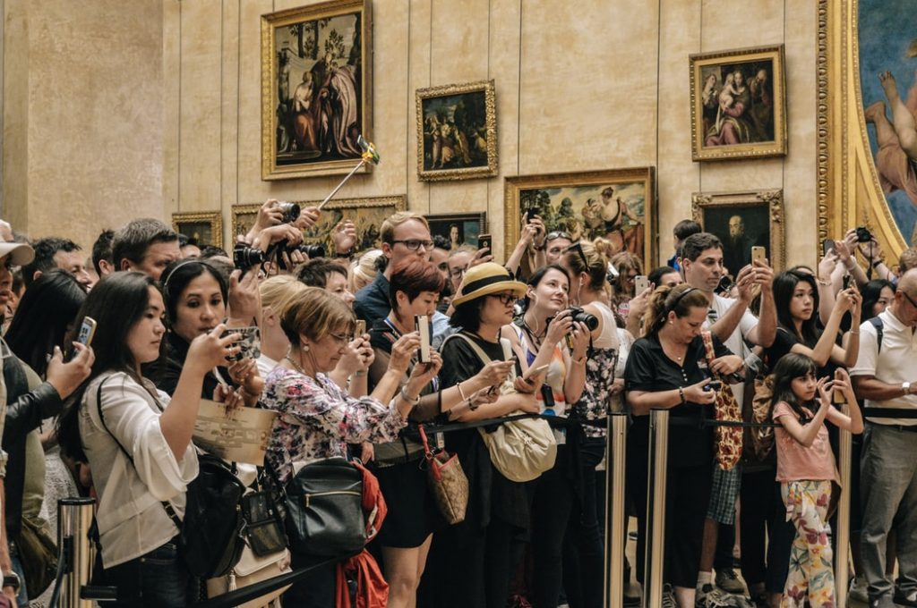 crowd of people trying to get pictures in a museum