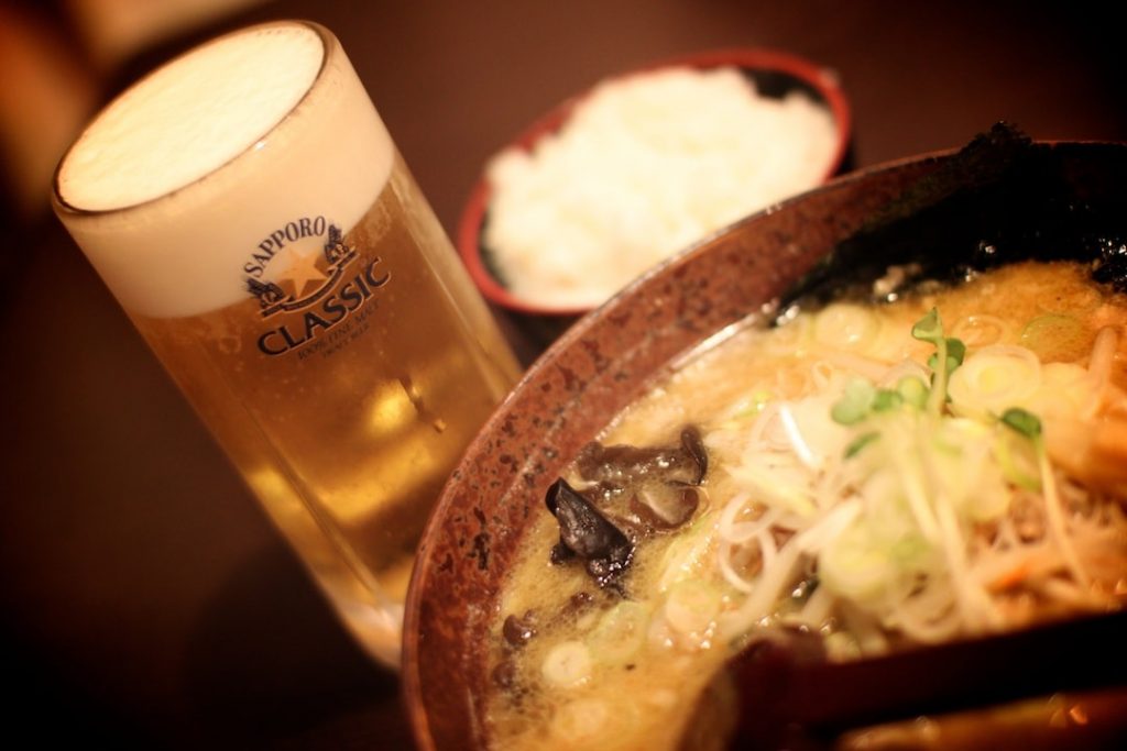 A glass of Sapporo beer and a bowl of ramen in Japan