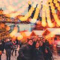 People taking a group photo beneath twinkling lights at the Toronto Christmas Market