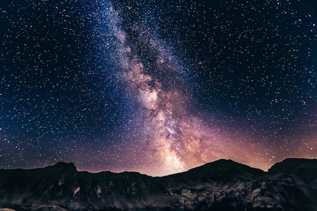 A mountain range with a star-studded sky and the Milky way overhead