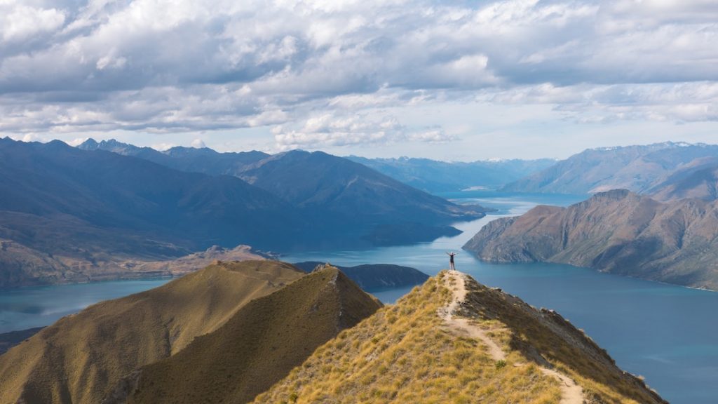 Person standing on top of Roy's Peak, New Zealand