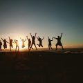 Group of people jumping at sunset