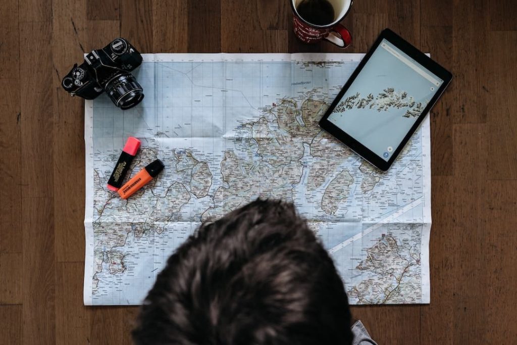 Person looking at a map with highlighters and a camera