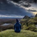 Woman sitting on lookout point on the Isle of Skye, Scotland