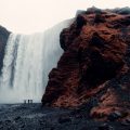 Three people standing in front of waterfall in Iceland