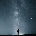Person standing in front of a starry sky with the Milky Way in the background