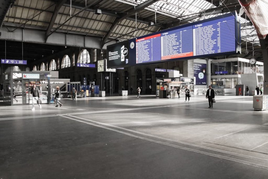 People walking through an empty train station in Switzerland