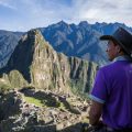 Man stands with back to us as he looks out at Machu Picchu