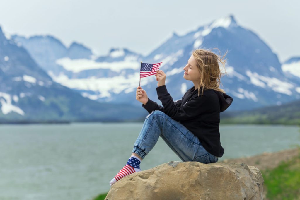 girl-sitting-on-a-rock-with-usa-flag